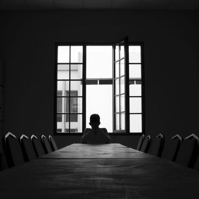 Person in a lonely conference room in a meeting without prupose.
